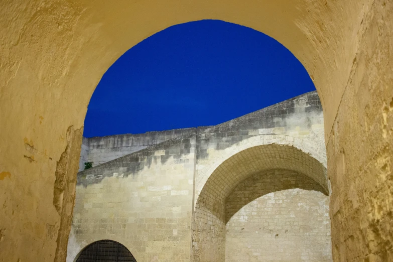 a clock sitting on top of a wall under a blue sky