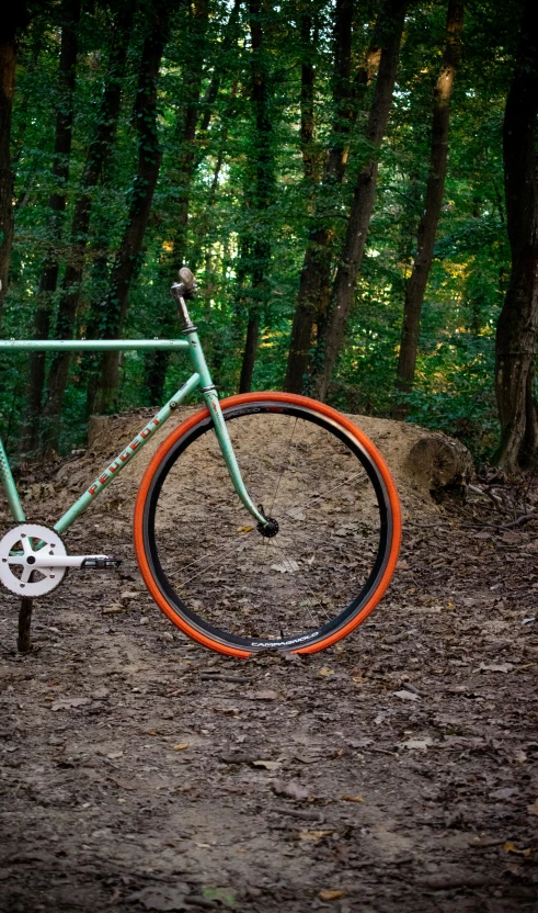 an orange rim is against the frame of a mountain bike