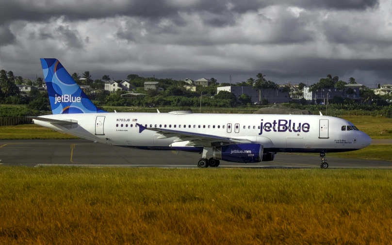a blue and white jet is on a runway