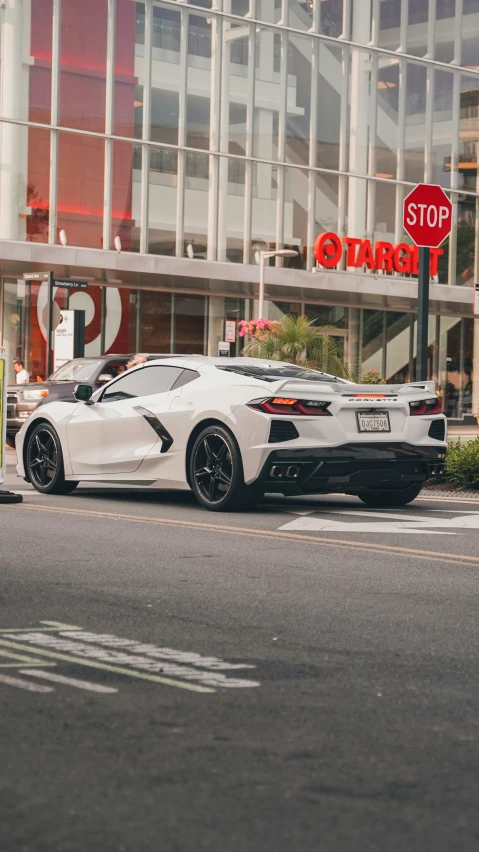 a sports car is parked at a stop sign