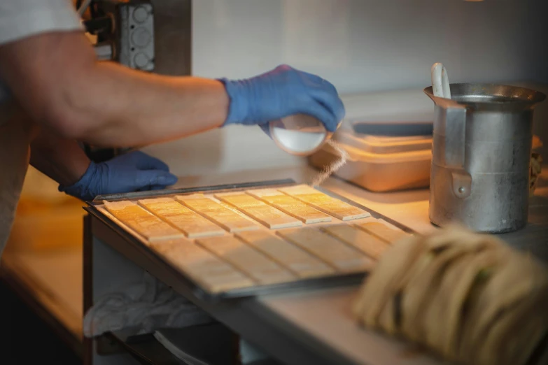 a man in blue gloves and latex gloves baking food