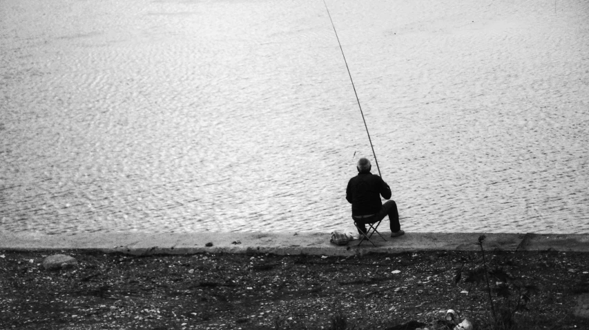 a person kneeling down while holding onto an umbrella fishing