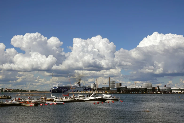 many boats on the river with buildings in the distance