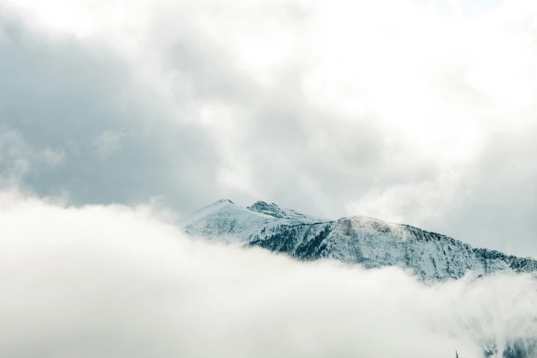 some snow and clouds around some mountains