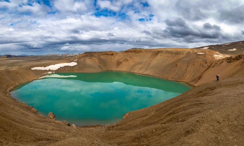 a large lake in the middle of a barren mountain