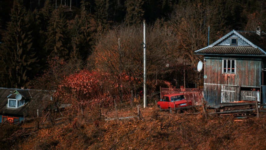 there is an old red truck parked in the woods