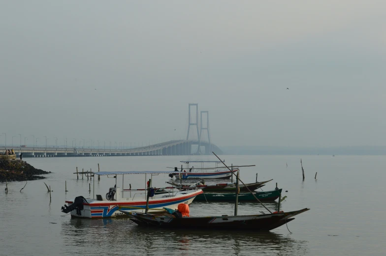 a foggy view of several boats in the water