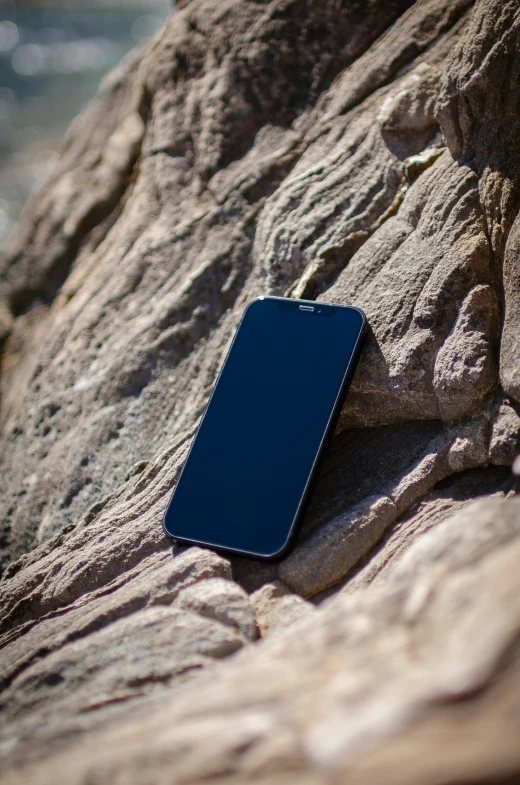 a cell phone laying on top of a rock