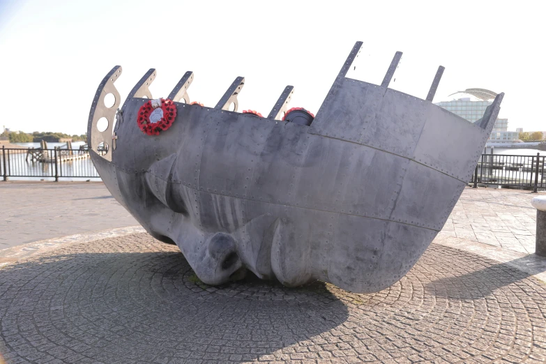 a concrete sculpture of a boat with a wreath on it