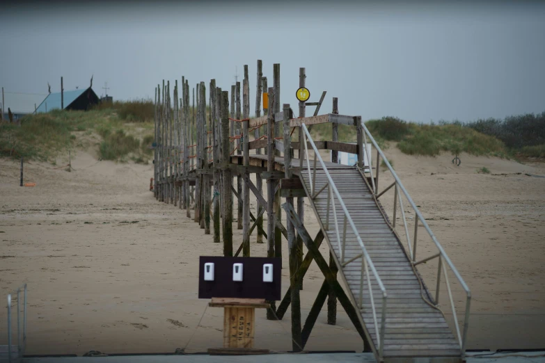 stairs made from sand on a beach with a walkway leading down to the ocean