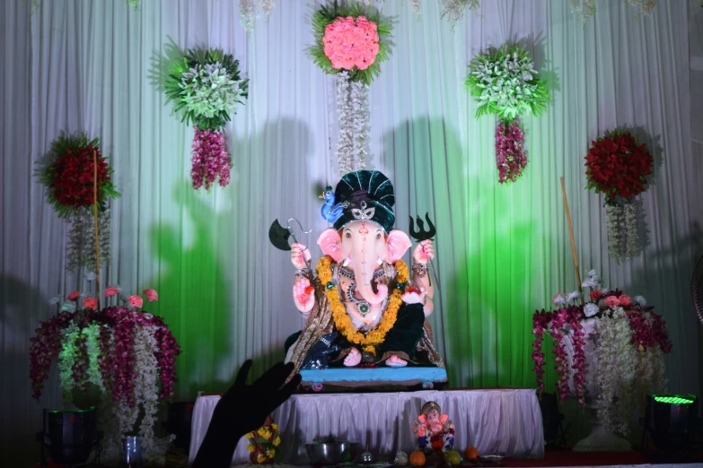 a ganesha sits on a table with many decorations