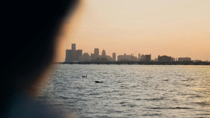 a boat in the water near a skyline with skyscrs