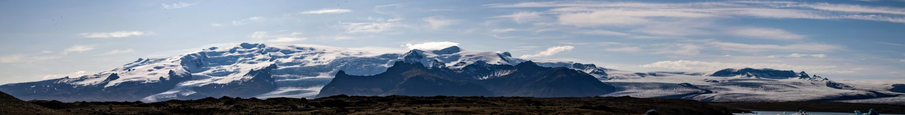 a snow covered mountain range from the waters