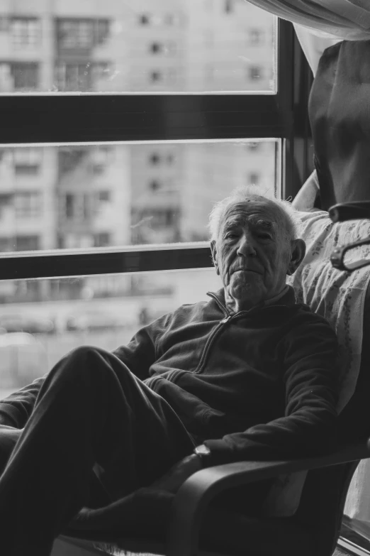 an old man in a chair by a window