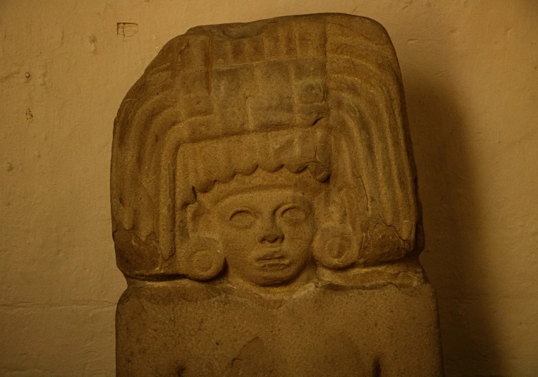 the carving in front of a wall is of an old woman's head