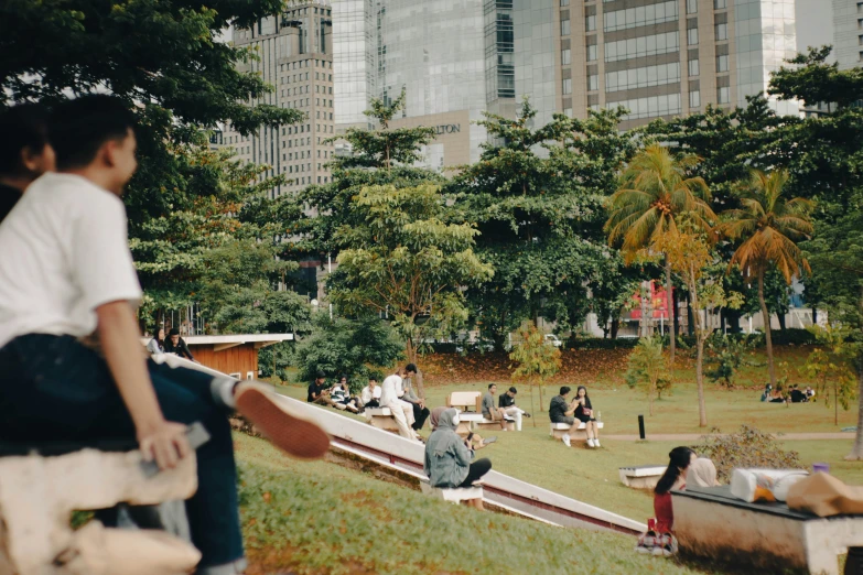 many people are sitting and laying in the grass