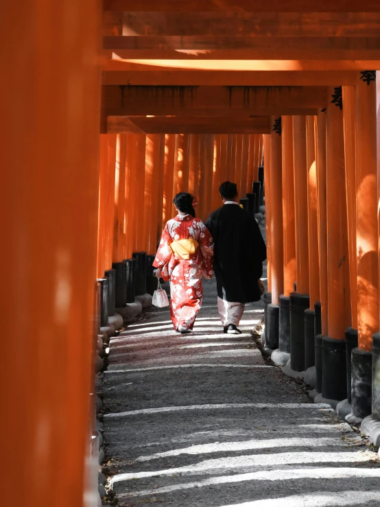 two people are walking up an alley in an orange tunnel