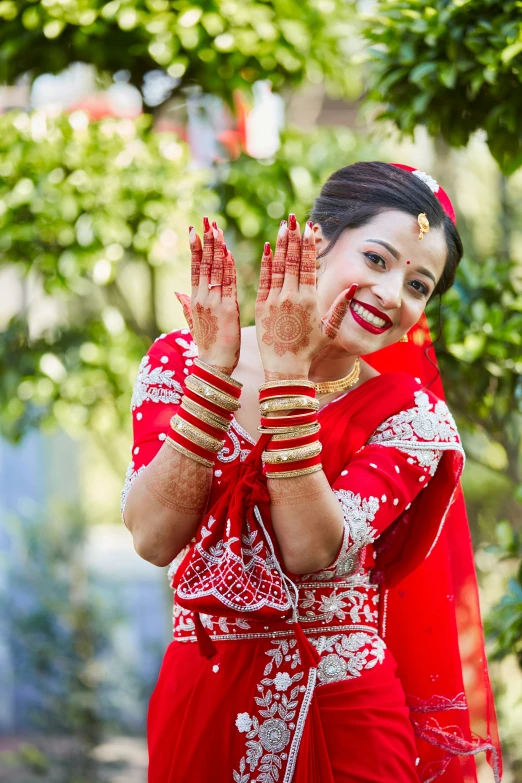 a beautiful young lady in traditional dress with her hands covered with hendi