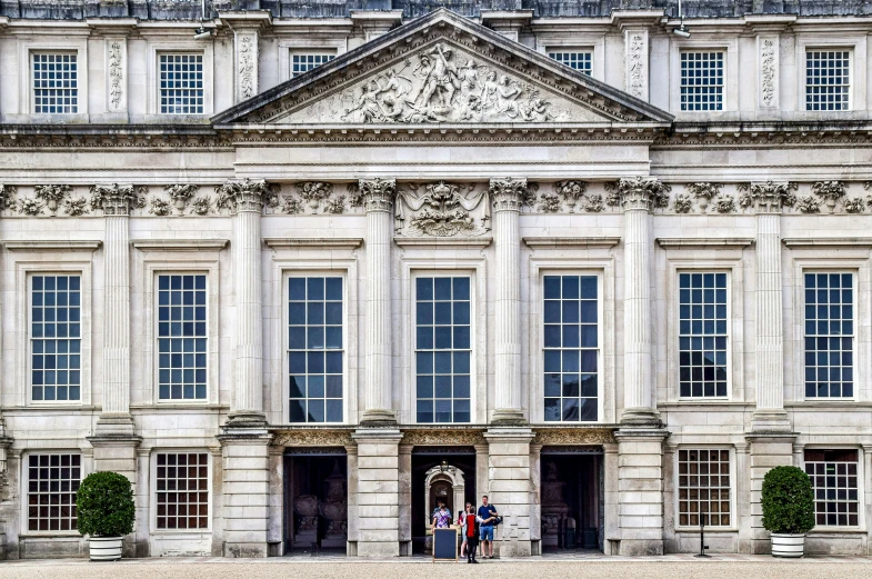 people in front of large white building with two doors