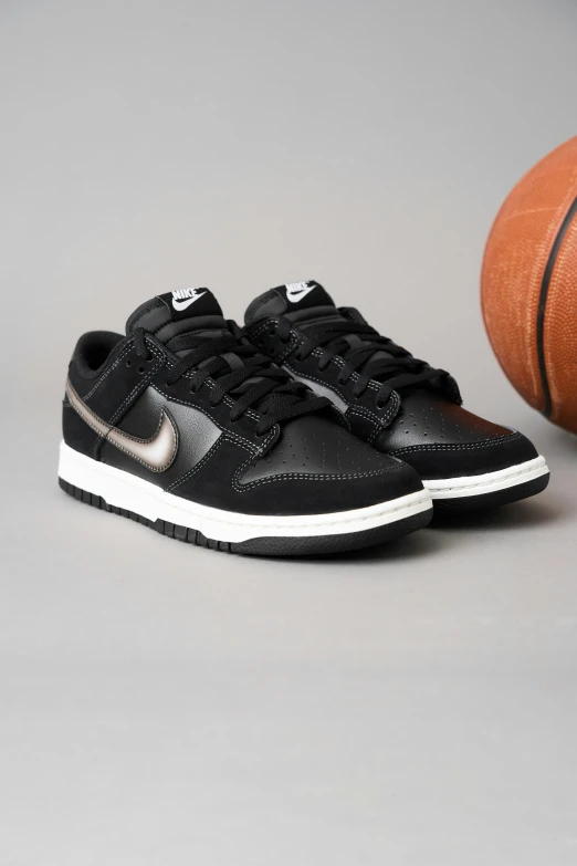a black nike sneaker is next to a basketball
