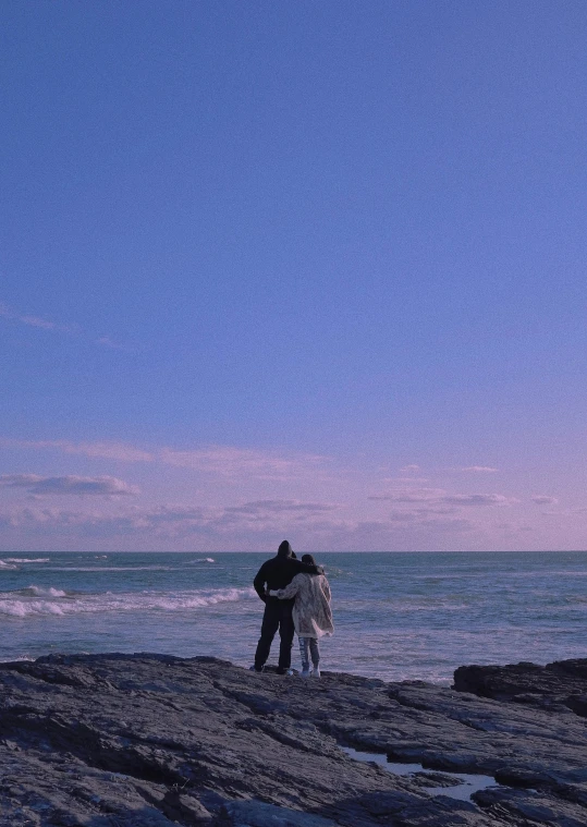 a person standing on the edge of a beach holding onto a kite