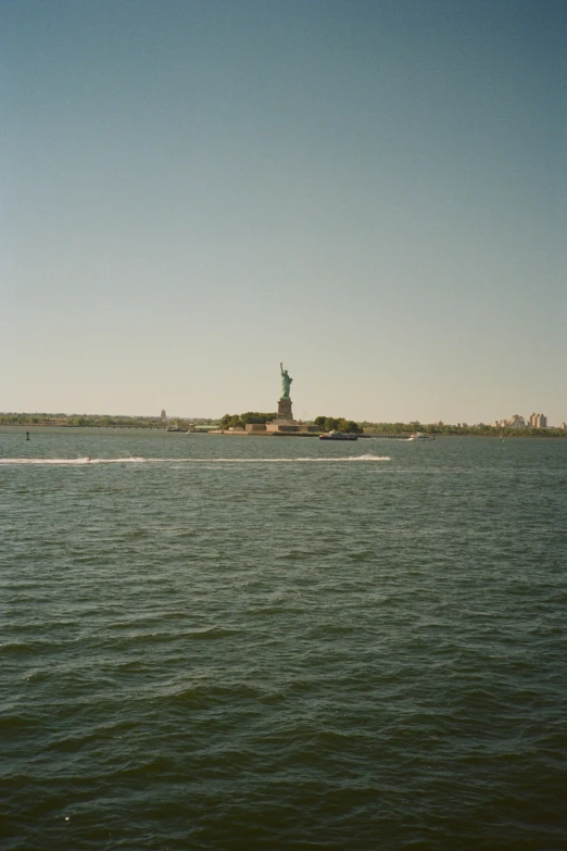 a view of a lake with a statue of liberty behind it