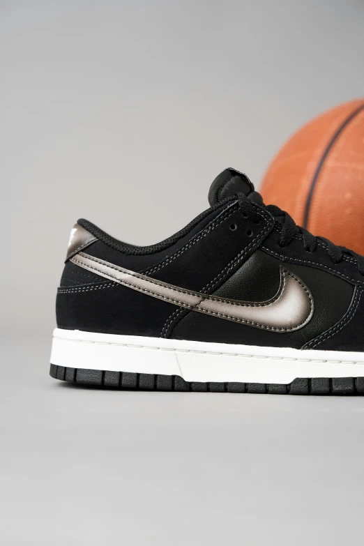 black nike low top basketball shoe next to a ball