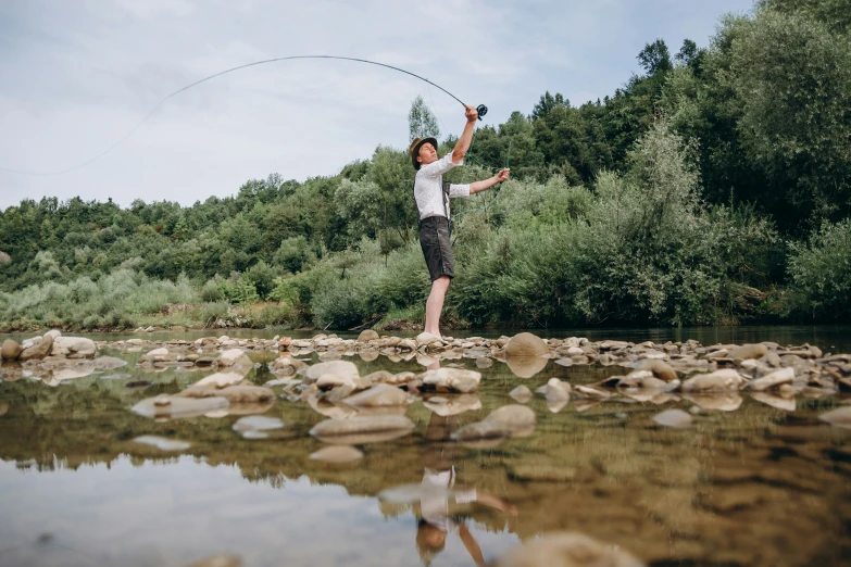 a boy playing with a kite in a stream