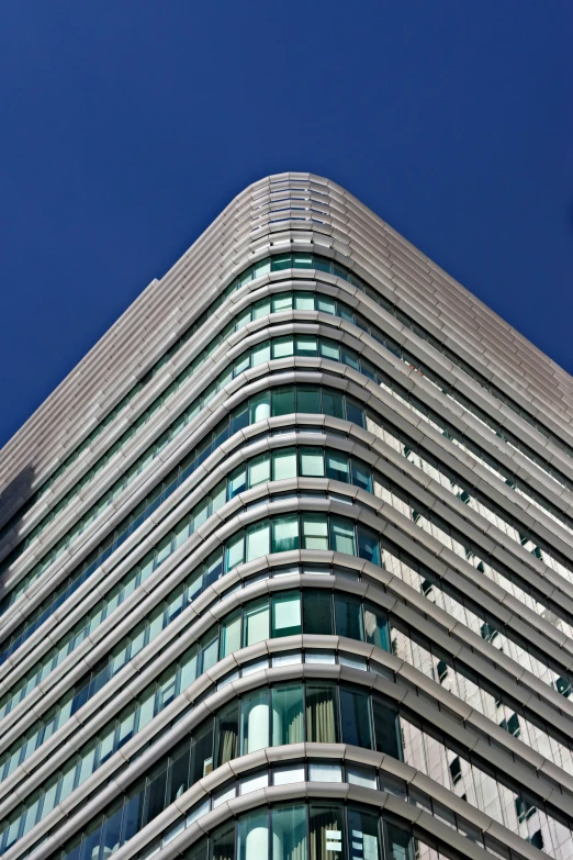 the corner of a multi story office building against a blue sky