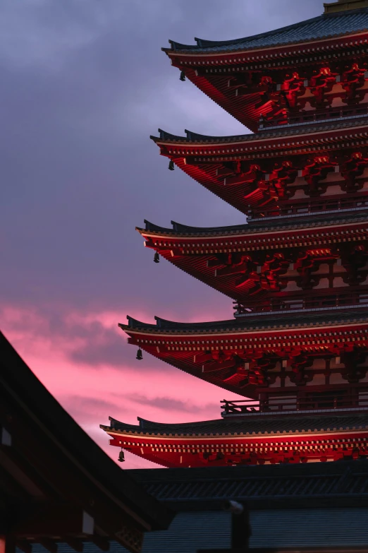 many buildings on the outside with a very pink sunset