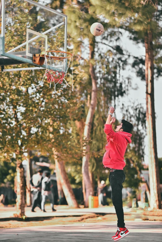 a young man is playing basketball in the street