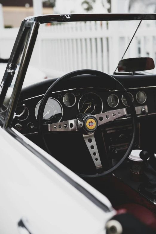 view of a white car dashboard with steering wheel and dashboard lights