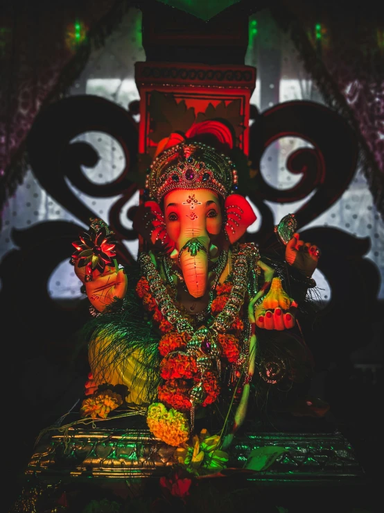 statue of ganesh with tusks and a green head covering