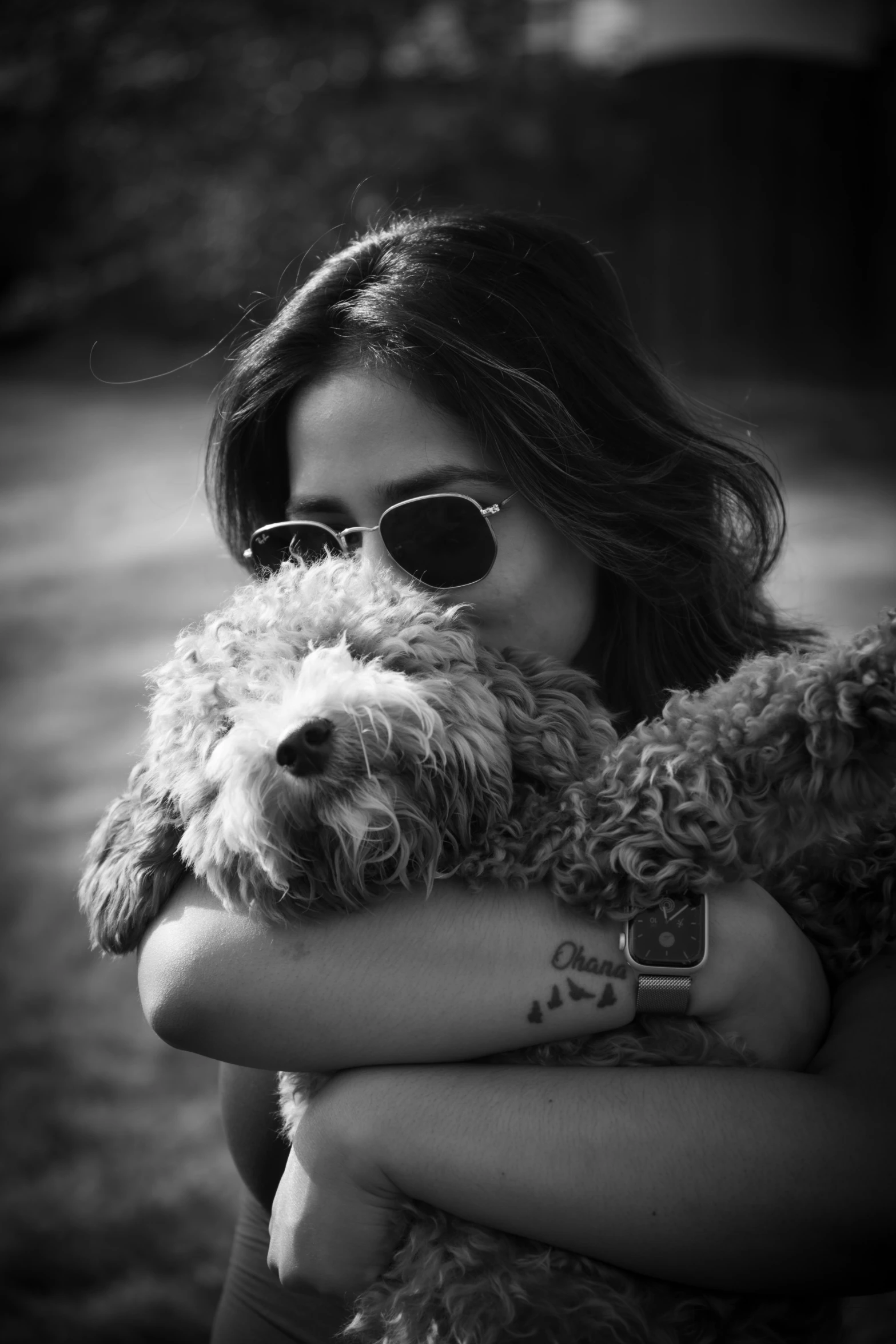 a woman is hugging a small dog while posing