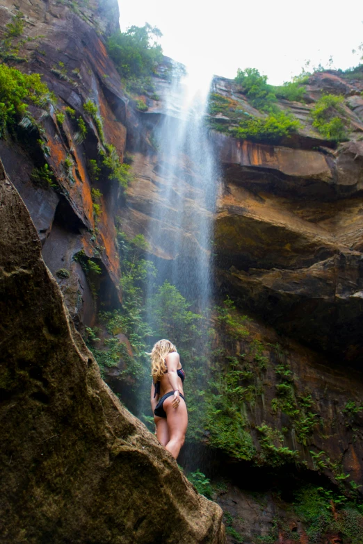 a women who is standing in front of a waterfall