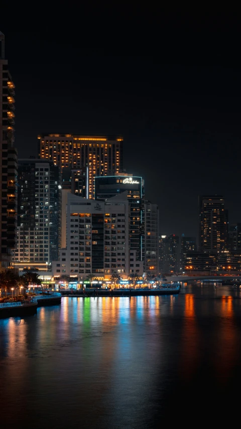 a night cityscape with high rise buildings by the water