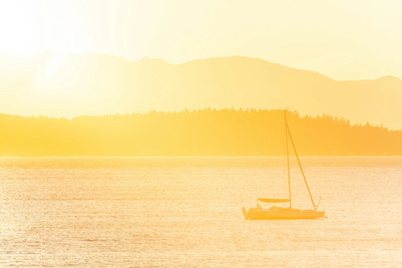 the boats are floating in the water with mountains in the background