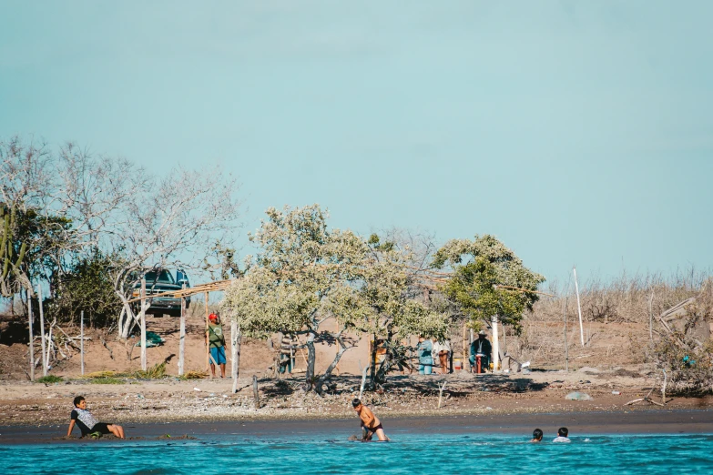 people are on the beach playing in the water