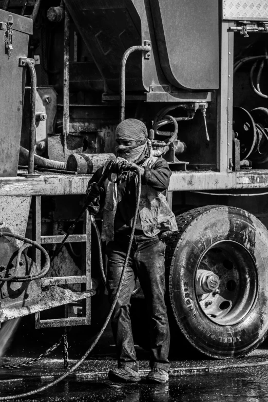 the man is cleaning his truck with a hose