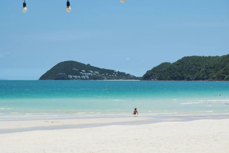 people are on the beach and a mountain in the background