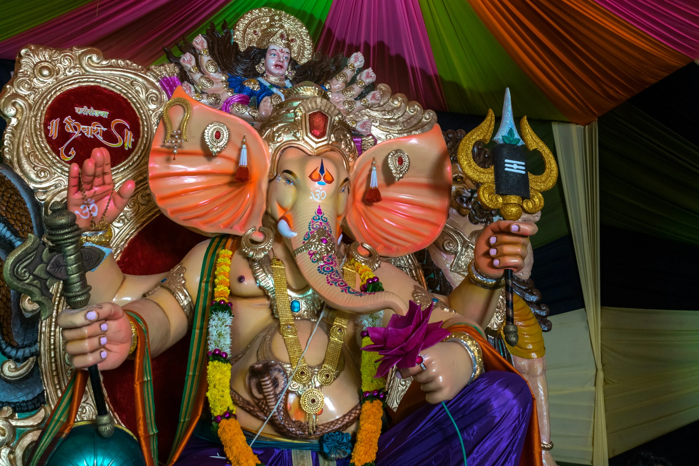 a statue of ganesh and the goddess sit in front of a tent