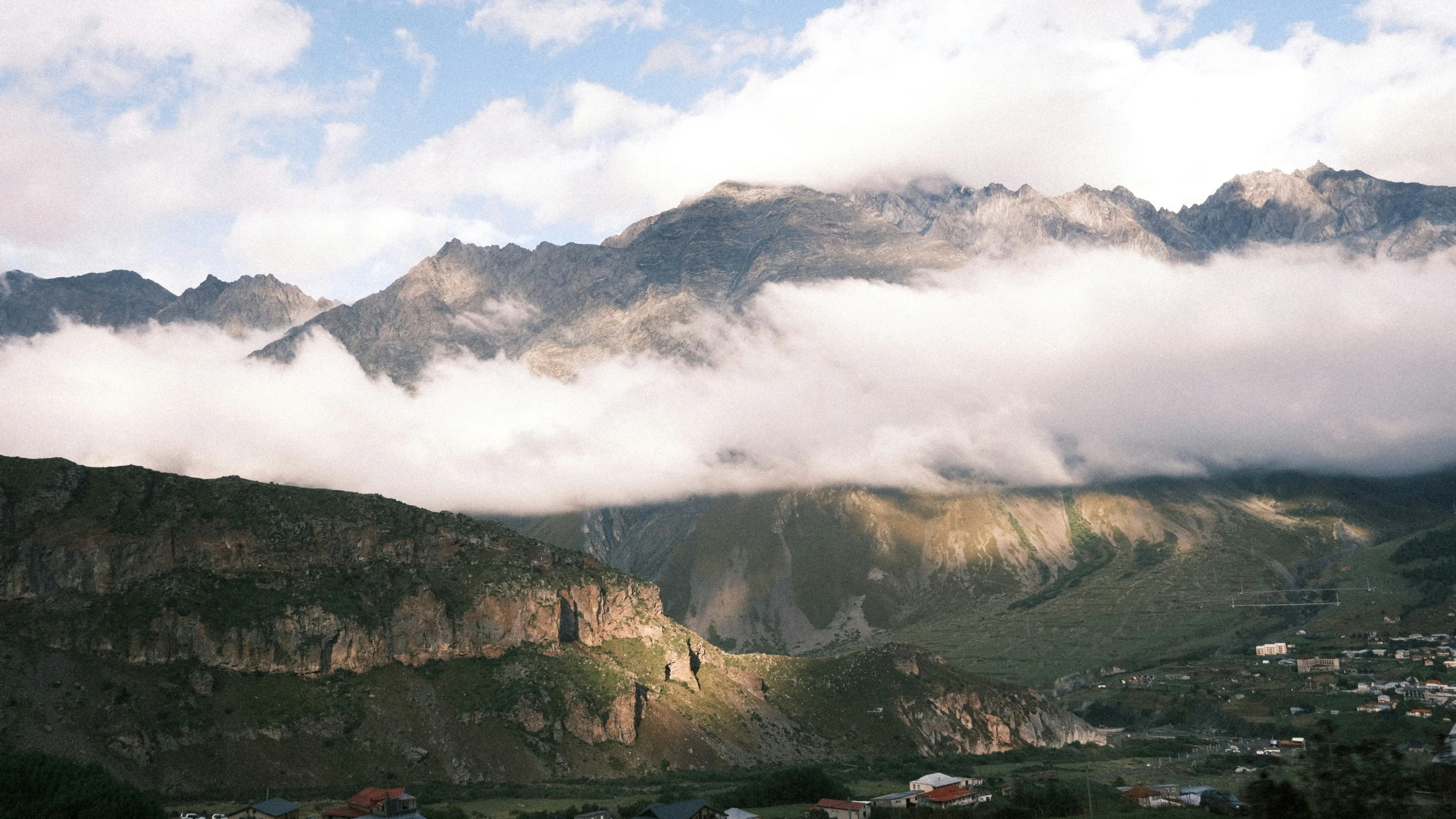 there are clouds moving in the mountains on this cloudy day