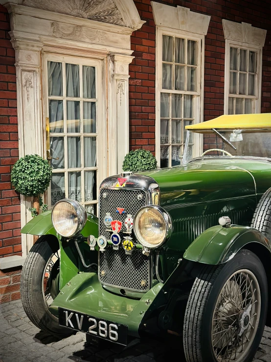 an old fashion green car is parked outside a building