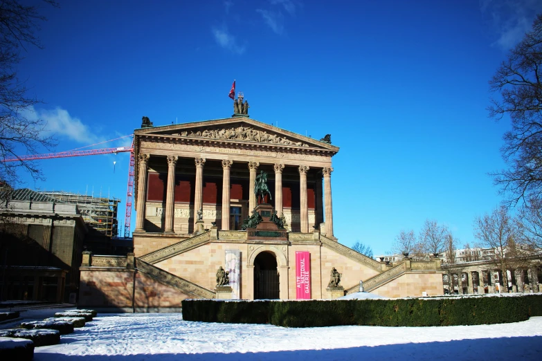 a large building with columns and pillars next to a tree