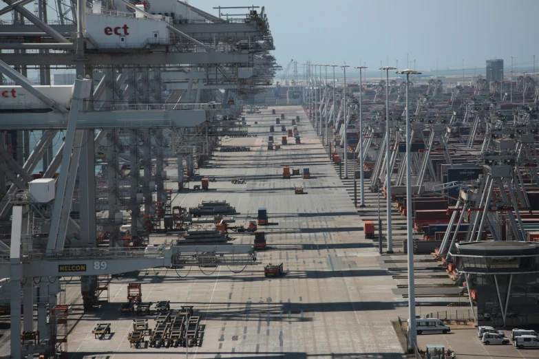 a large row of industrial cranes and cargo containers at an industrial port