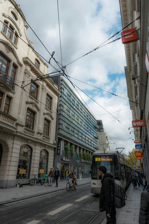 a tram traveling down a street next to some tall buildings