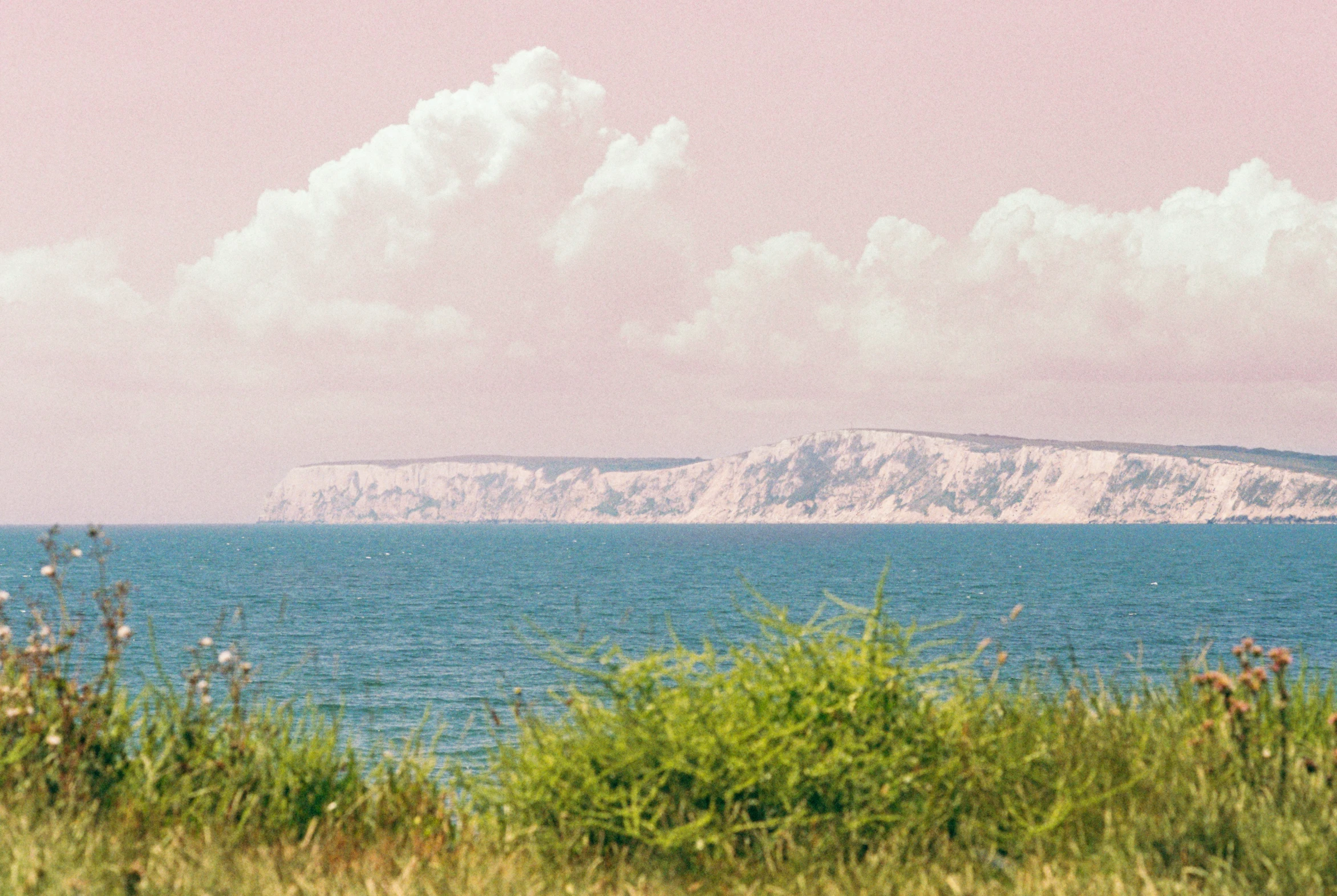 a lone mountain with some clouds in the background