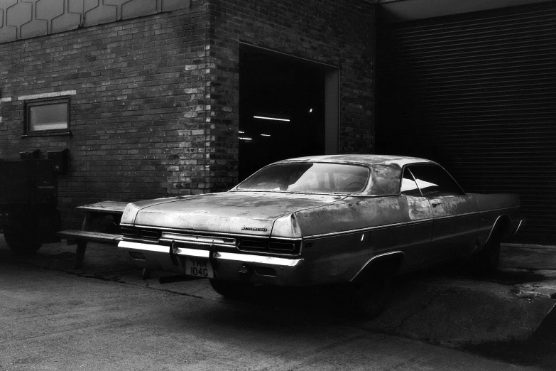 the old car is parked in front of a building