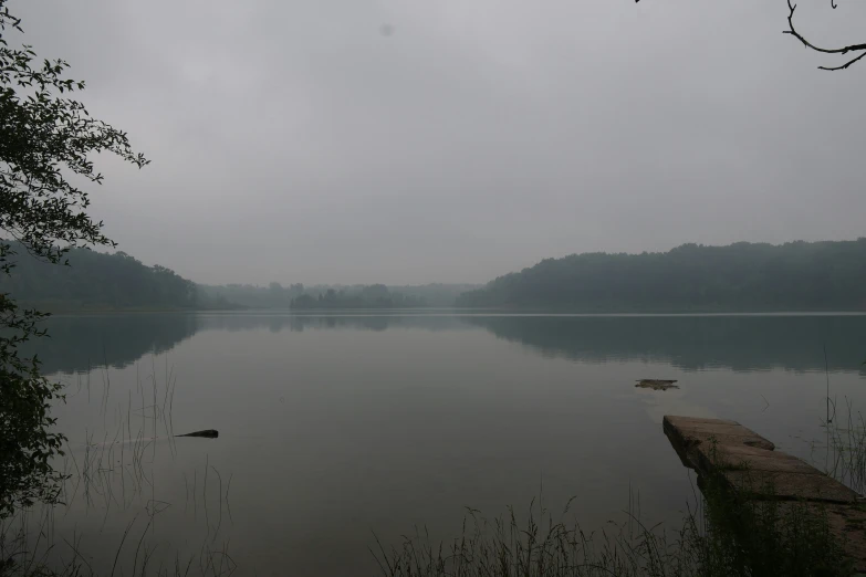 lake in fog with boat on the water