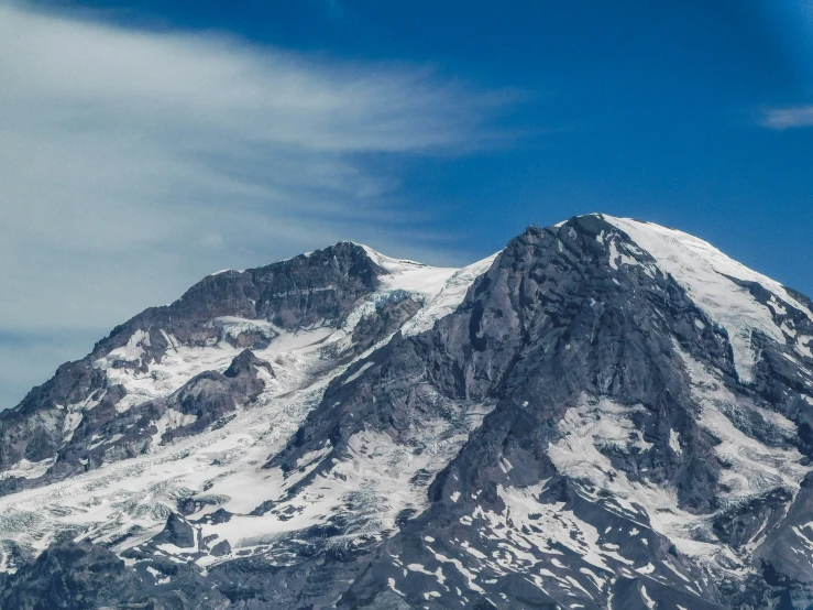 a large snow covered mountain peak in the middle of winter